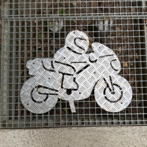 plaque metal symbole moto avec un motar avec des rayures uniformes anti dérapent aspect inox. Le tout sur une grille métallique